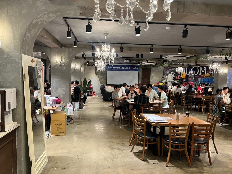 여러 테이블과 좌석이 배치된 컬컴 건대점 실내 전경