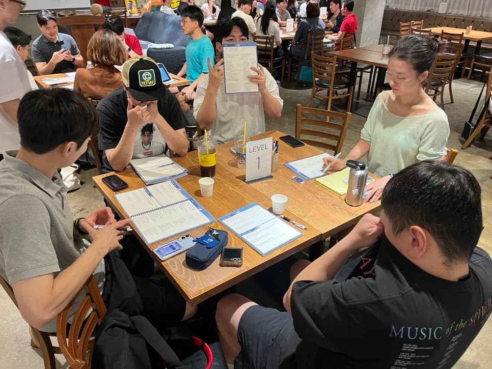 서로 마주 앉아 자료를 살펴보는 스터디 장면