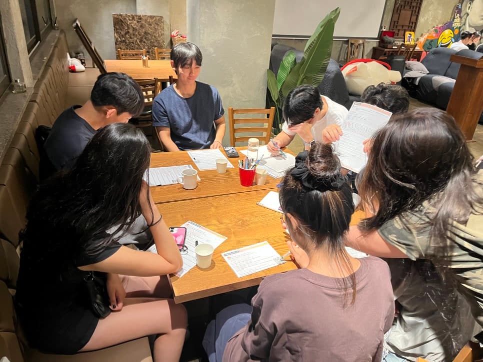 창가와 벽면 옆 테이블에 모여 있는 참여자들