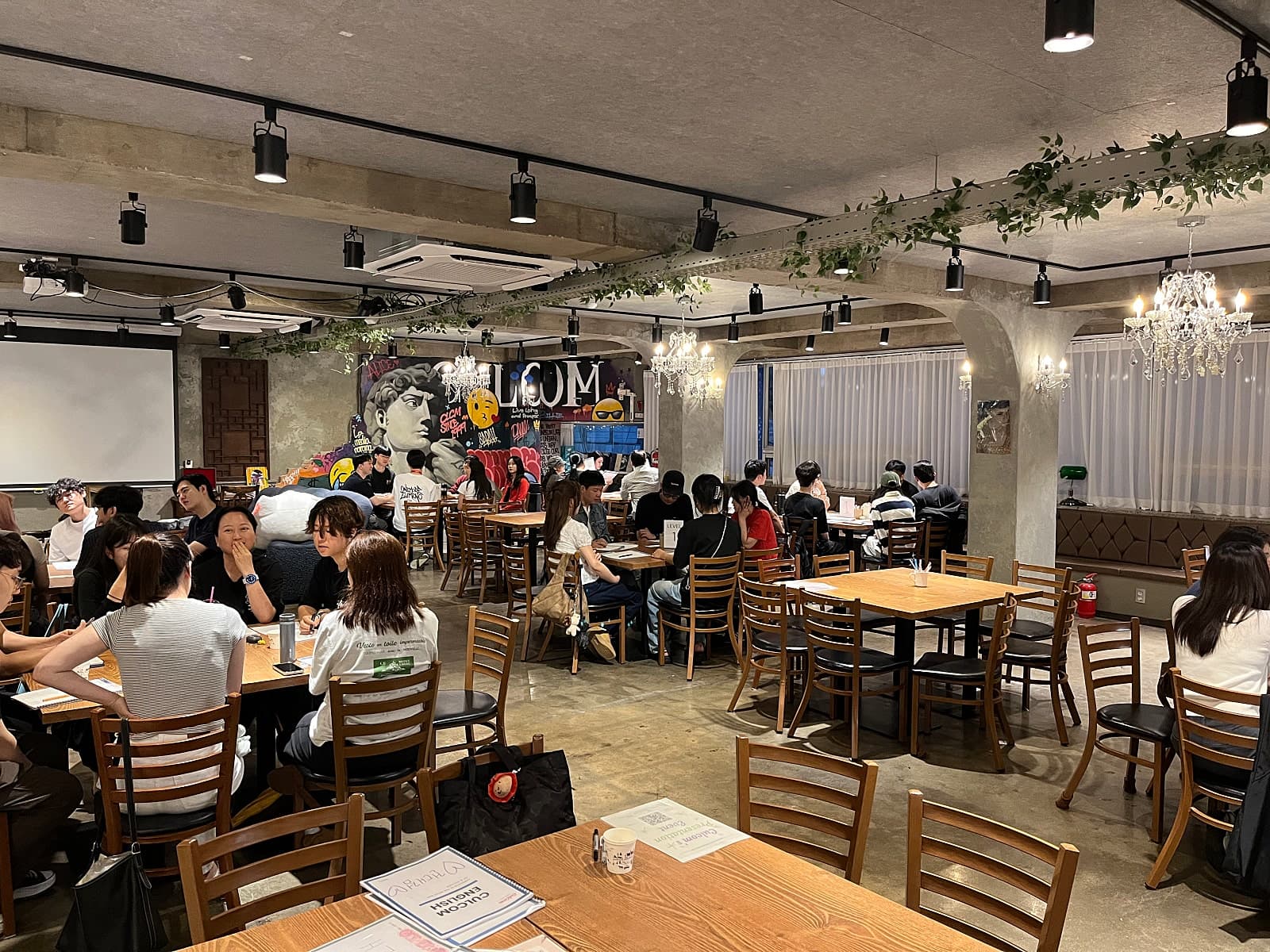 여러 사람이 테이블에 둘러앉아 있는 컬컴 건대점 내부
