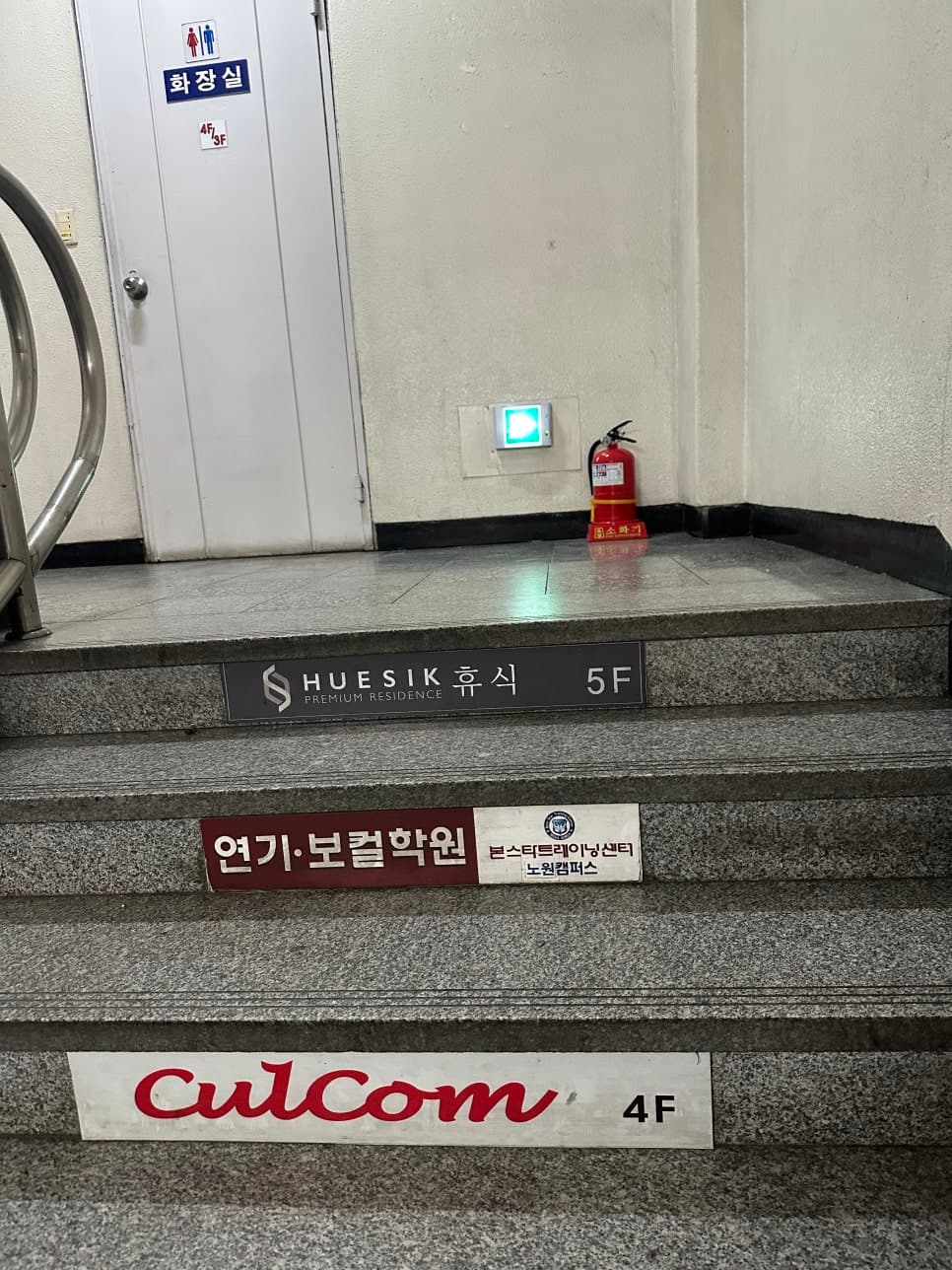 계단에 컬컴 4층 안내가 표시된 건물 내부
