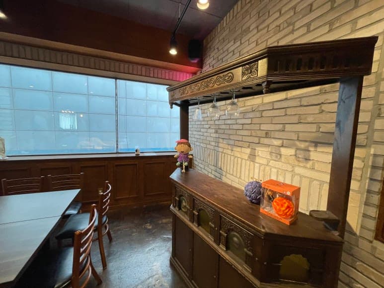 벽돌 벽면과 창가 옆에 놓인 테이블과 의자