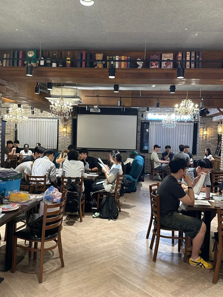 여러 테이블로 나뉘어 앉아 있는 참여자들