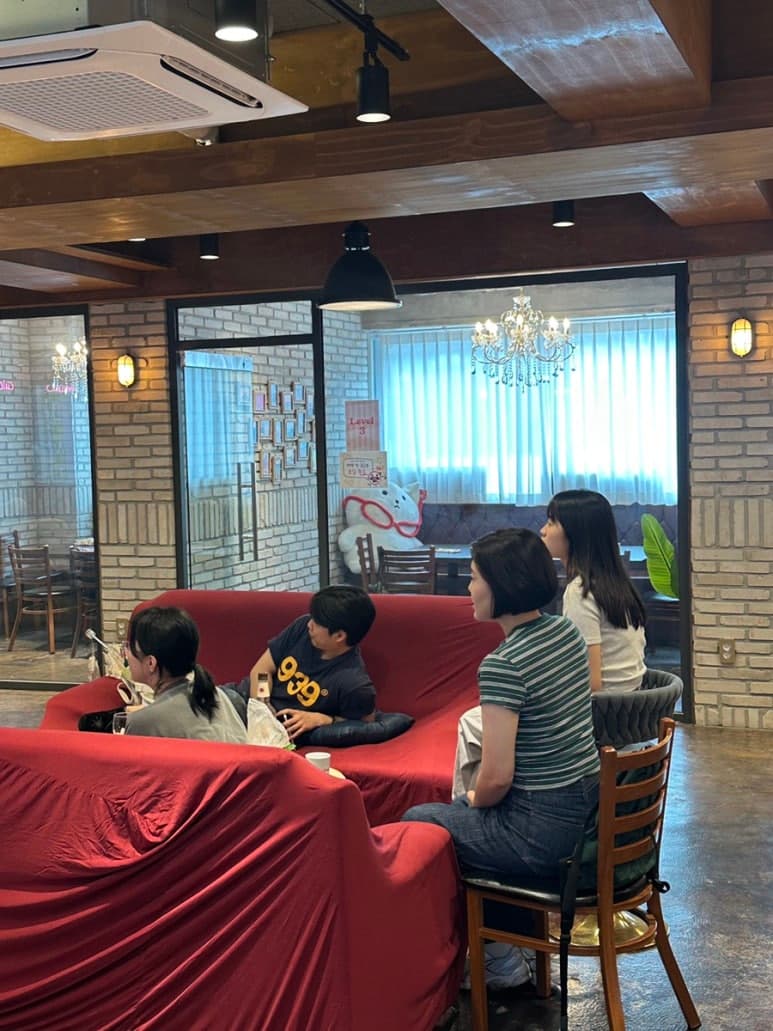 빨간 소파 주변에서 사람들이 이야기하는 모습