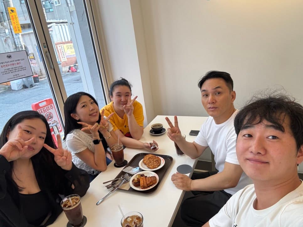 식당 테이블에 둘러앉아 함께 사진을 찍은 모습