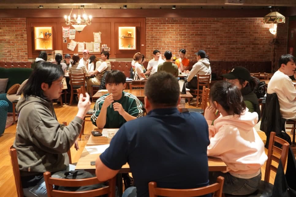 여러 테이블에 참여자들이 둘러앉아 있는 컬컴 의정부점 내부