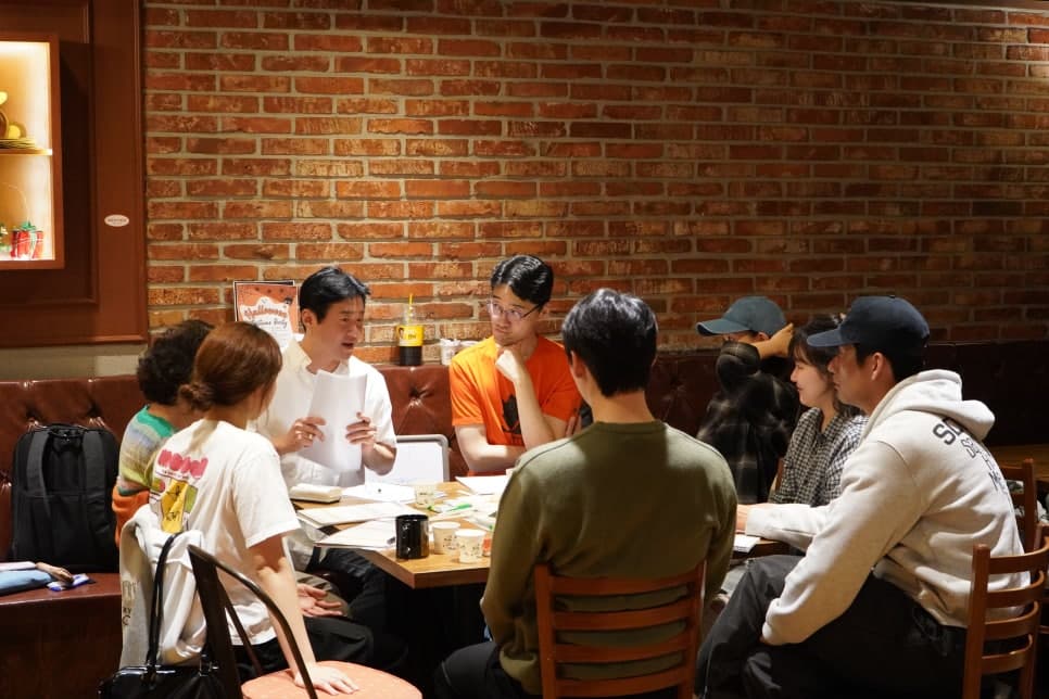 여러 사람이 같은 테이블에 둘러앉아 대화하는 모습