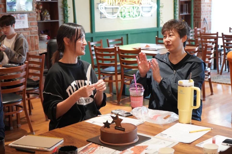 테이블에 마주 앉아 이야기하는 참여자들