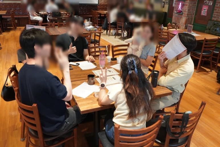 학습 자료를 펼치고 테이블에 둘러앉은 참여자들