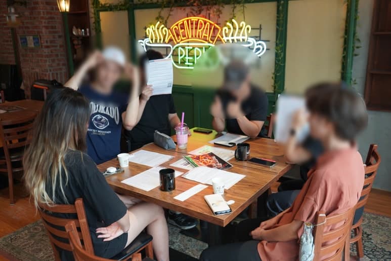 원형 테이블에 앉아 이야기하는 참여자들
