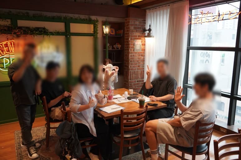 실내 테이블별로 나뉘어 앉아 있는 참여자들